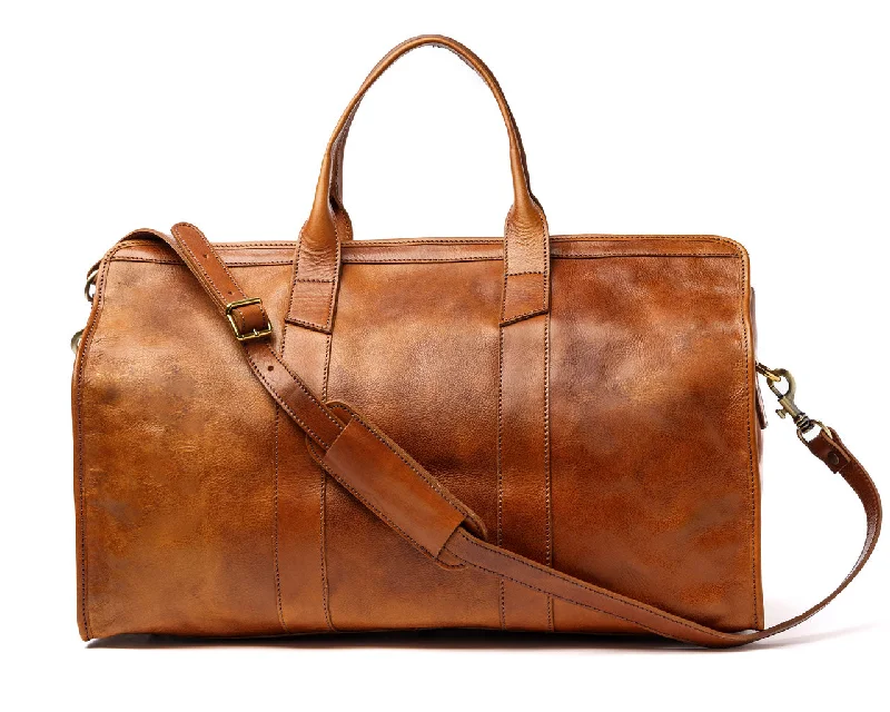 Vintage leather travel bag with brass accents for a classic and sophisticated lookOn The Move Vintage leather travel bag with brass accents for a classic and sophisticated lookOn The Move